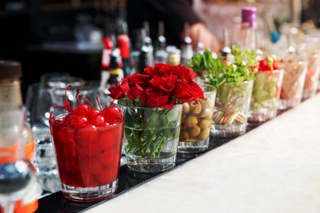 Cocktail cherries, herbs and flowers on bar counter