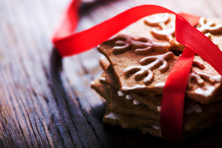Gingerbread cookies with red ribbon on rustic wooden backgroundの写真素材