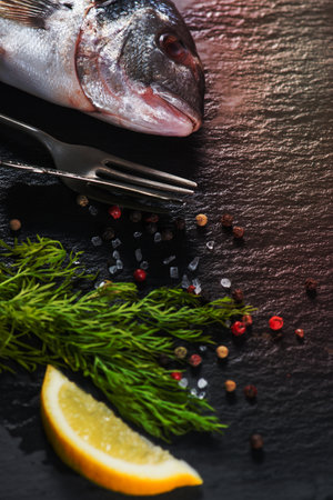 Fresh whole sea fish with aromatic herbs, cooking conceptの写真素材