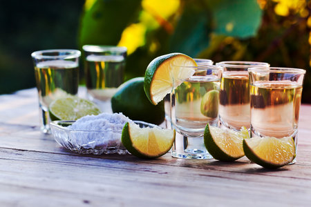 gold tequila with salt and lime on old wooden table.の写真素材