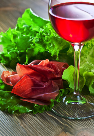 jamon and red wine on wooden tableの写真素材