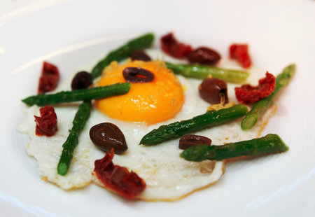Light and tasty fried egg with asparagus and olivesの写真素材