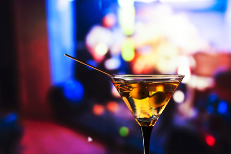 glass with martini , focus on a olivesの写真素材