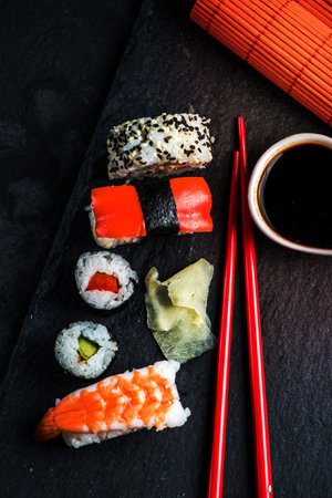 Sushi selection on black slate, food border backgroundの写真素材