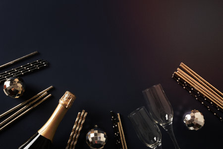 Composition with New Year champagne, drinking straws, shiny silver disco balls on blue navy background. View from above. Festive greeting card or invitation for party with copy space.の写真素材