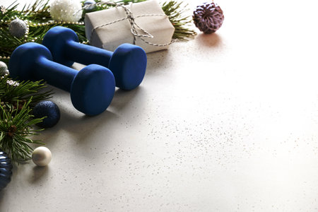 Christmas composition with blue dumbbells and gift on white background with copy space. Special offer. Close up. Fitness, sport and healthy lifestyle concept.の写真素材