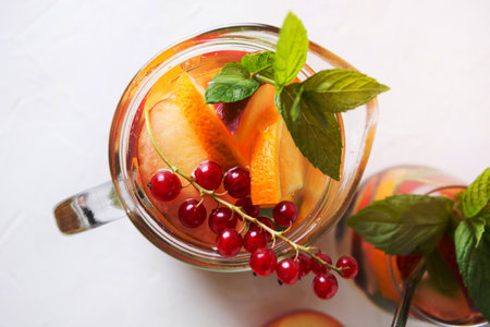 Freshness peach lemonade in jar garnish berry,currant, mint on white background. Summer drink. View...