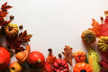 Seasonal harvest, pumpkins, colorful leaves on white background with space for text. Autumn composition. Concept of Halloween or Thanksgiving day. View from above.の写真素材