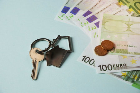 Keys from a new house and euro currency paper banknotes and cents. Close up. Concept expensive utility bills and house payments.の写真素材