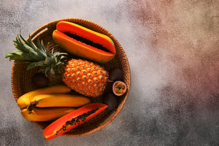 Popular Asian exotic fruits. Pineapple, passion fruit and papaya served in tray on gray background. Top view, copy space.の写真素材