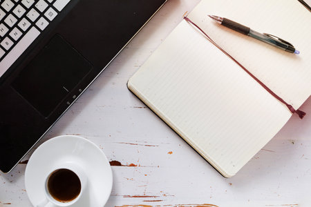 coffee notebook and laptop white wood background top view