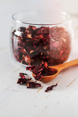 hibiscus tea in glass jar wood spoon white wood backgroundの写真素材