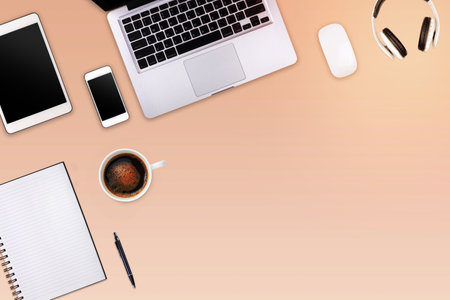 Modern workspace with laptop tablet, smartphone and coffee cup copy space on color background. Top...