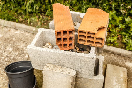 Bricks of different types and sizes in the yard of a house