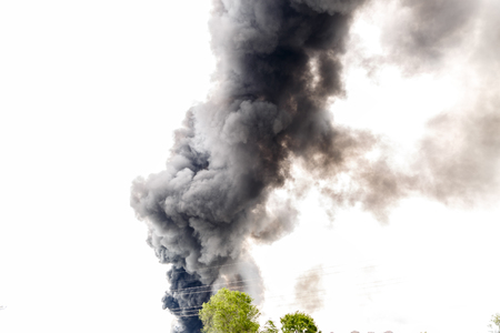Huge and gray column of smoke in the middle of the skyの写真素材