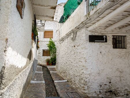Small street with a water channel in the middle, in a village of La Alpujarra, Granada, Spainの写真素材