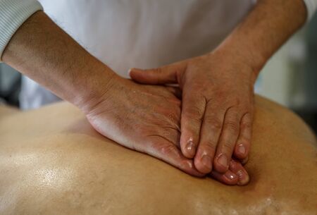 Therapist doing a relaxing massage on a man's back