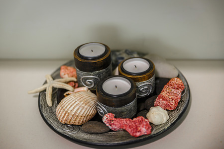 Set of candles and other things, on a plate on the table of a therapy centerの写真素材