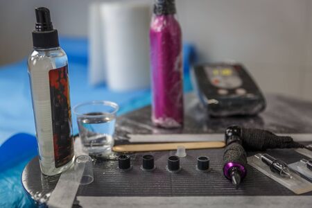 Small table with a set of tools and ink to make tattoosの写真素材