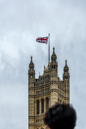 Young tourist observing the tower of parliament, London, UKの写真素材