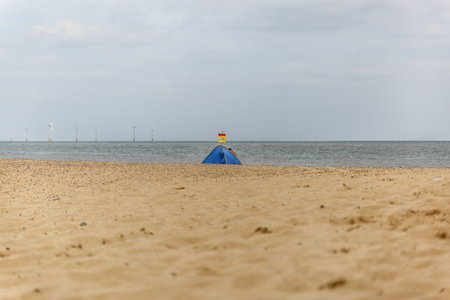 View of a beach with a blue tent near the shoreの写真素材