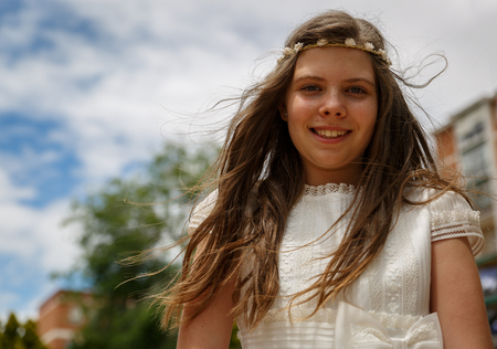 Outdoor portrait of a beautiful blond girl in her communion dressの写真素材
