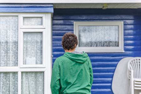 A boy is next to a blue bungalow, in a European campsiteの写真素材