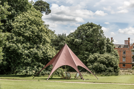 Curious stand with chairs below in the middle of one of the gardens of Blickling Hall, Norfolk, UKの写真素材
