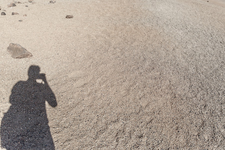 Shadow of a photographer on the warm sand of a desert, on the island of Tenerife, Spainの写真素材