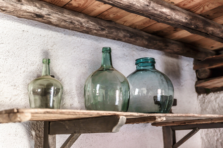 Three wide bottles of green glass, on an old shelf in a very old house, Spainの写真素材