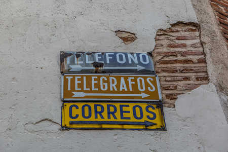 Telephone signs, telegraphs and post office in Spanish language, in a corner of a town in Spainのeditorial素材