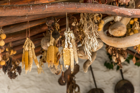 Cobs hanging from an old wooden roof, in a large courtyard of a village in Spainの写真素材
