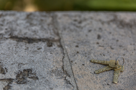 Group of three silver keys placed on top of a smooth rock