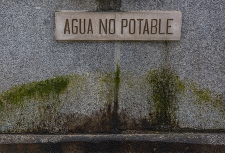 Water Poster not drinkable in Spanish in an old stone fountainの写真素材