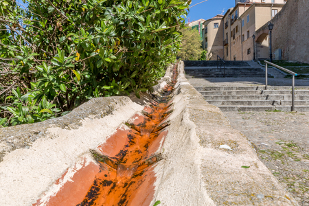 Water channel on the side of an old street with many stairs in the city of Segovia, Spainの写真素材