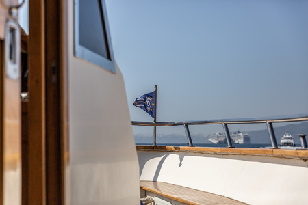 Bridge of a large luxury yacht with a beautiful sea and boats in the background