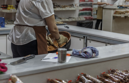 A woman makes a mixture of almonds inside a factory of almond candy assortments