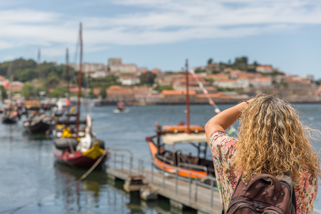 A tourist takes a photo of the famous rabelos boats in the city of Oporto. The rabelo boat is a Portuguese boat, typical of the Douro River. Portugalの写真素材