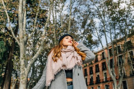 Young blonde girl with closed eyes breathes relaxed in a city park on an autumn day