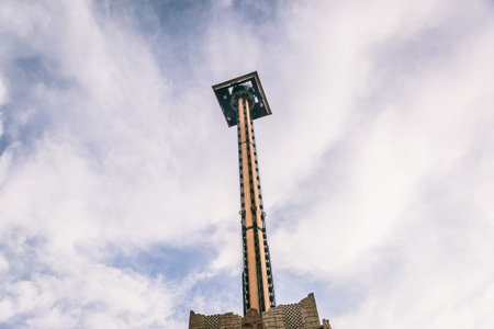 View from below of large tower in a theme park, with a nice sky in the background
