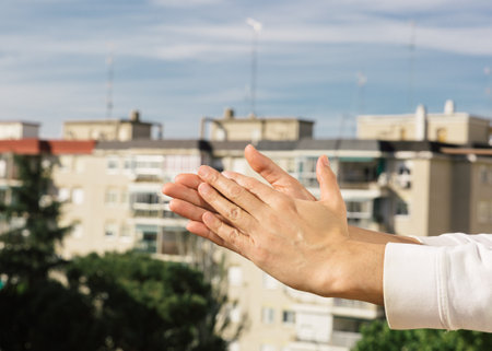 Applause from the balcony of an apartment with the city in the background