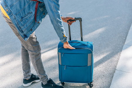 View of a the hand of traveler searching for something in his luggage in the streetの写真素材