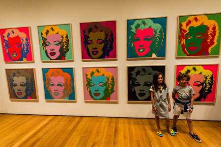 NEW YORK, MUSEUM OF MODERN ART - AUGUST 23: A girl stands in the front of the famous Marilyn Monroe picture from Andy Warhole in the Museum of Modern Art in New York an August 23, 2015.のeditorial素材