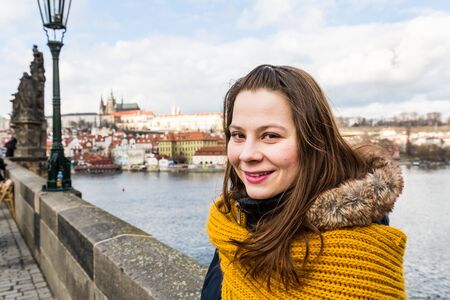 A girl in front of the charles bridge in Prague, Czech Republicの写真素材