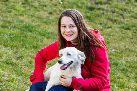 A young woman is playing with pets in the garden