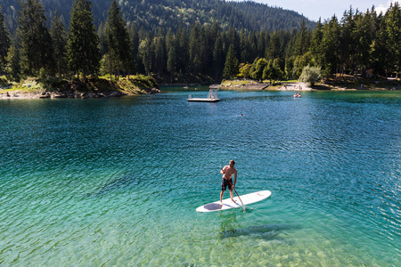 View of a man on a paddleboard at Caumasee in Switzerland