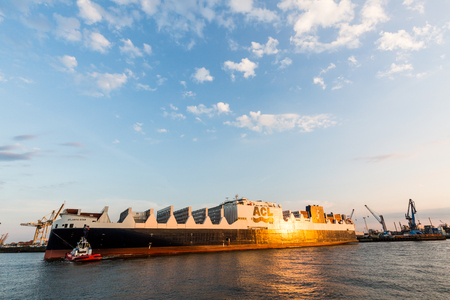 HAMBURG, GERMANY - JUNE 6, 2016: View of a big container ship at sunset in the Port of Hamburg and the Elbe river on June 6, 2016. Hamburgs large harbour is important for Europes trade in goods.のeditorial素材