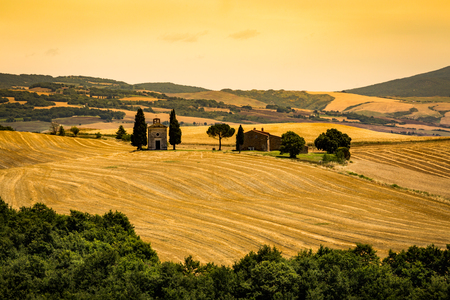 SAN QUIRICO D ORCIA, ITALY - JULY 16, 2016: View of a farm house and church in the tuscan region San Quirico d Orcia in Italy on July 16, 2016. This region is popular for tuscan style photographic motives.のeditorial素材