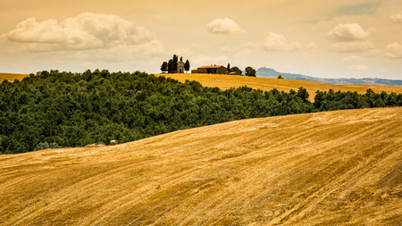 SAN QUIRICO D ORCIA, ITALY - JULY 16, 2016: View of a farm house and church in the tuscan region San Quirico d Orcia in Italy on July 16, 2016. This region is popular for tuscan style photographic motives.のeditorial素材