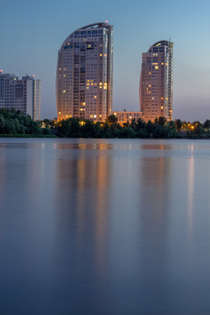 Night city buildings reflected in river water. Vertical. HDR.の写真素材